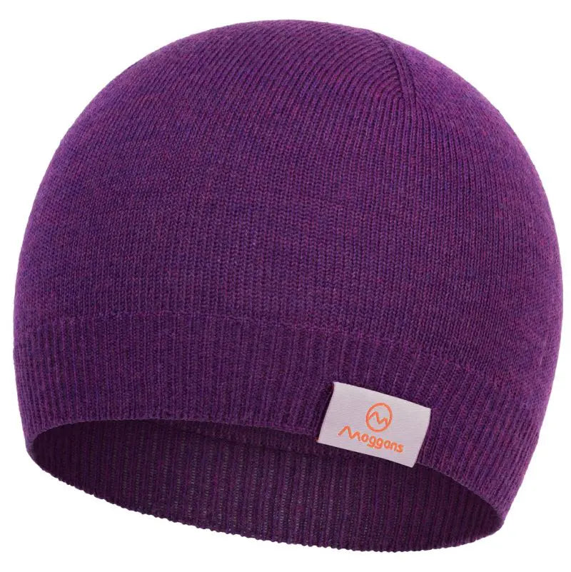 The Moggans 100% Merino Wool Beanie in purple, made in Scotland and mulesing-free, features a folded brim and a white rectangular tag with an orange Moggans logo on the front.