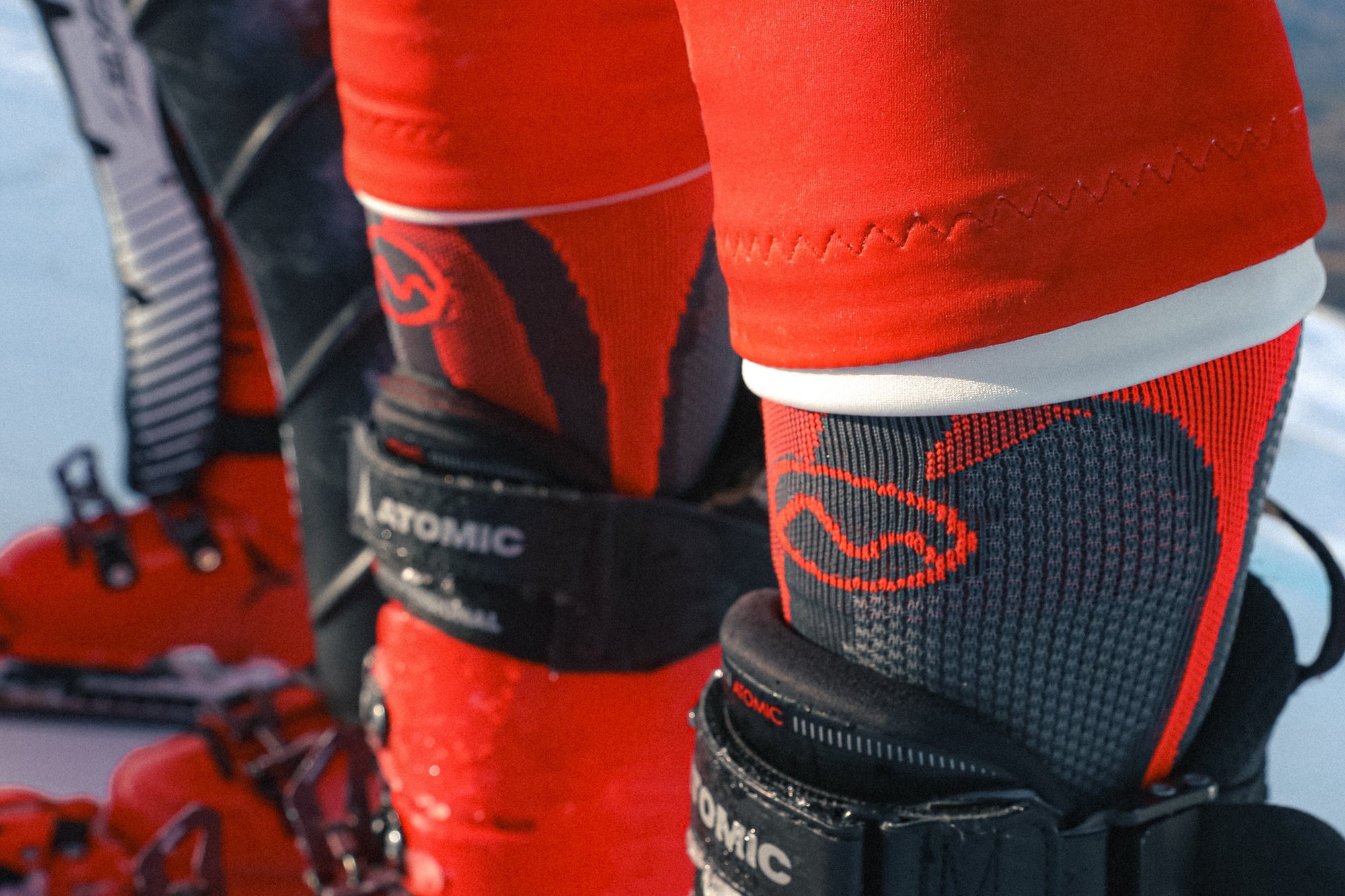 Close-up of red ski boots with black bindings on a snowy background