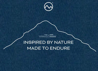 A blue textured Moggans Cotton Tee by Moggans featuring a simple white outline of Buachaille Etive Mòr (1021m, NN222542), circular logo above, and the text: INSPIRED BY NATURE MADE TO ENDURE. Perfect Scotland t-shirt for mountain lovers.