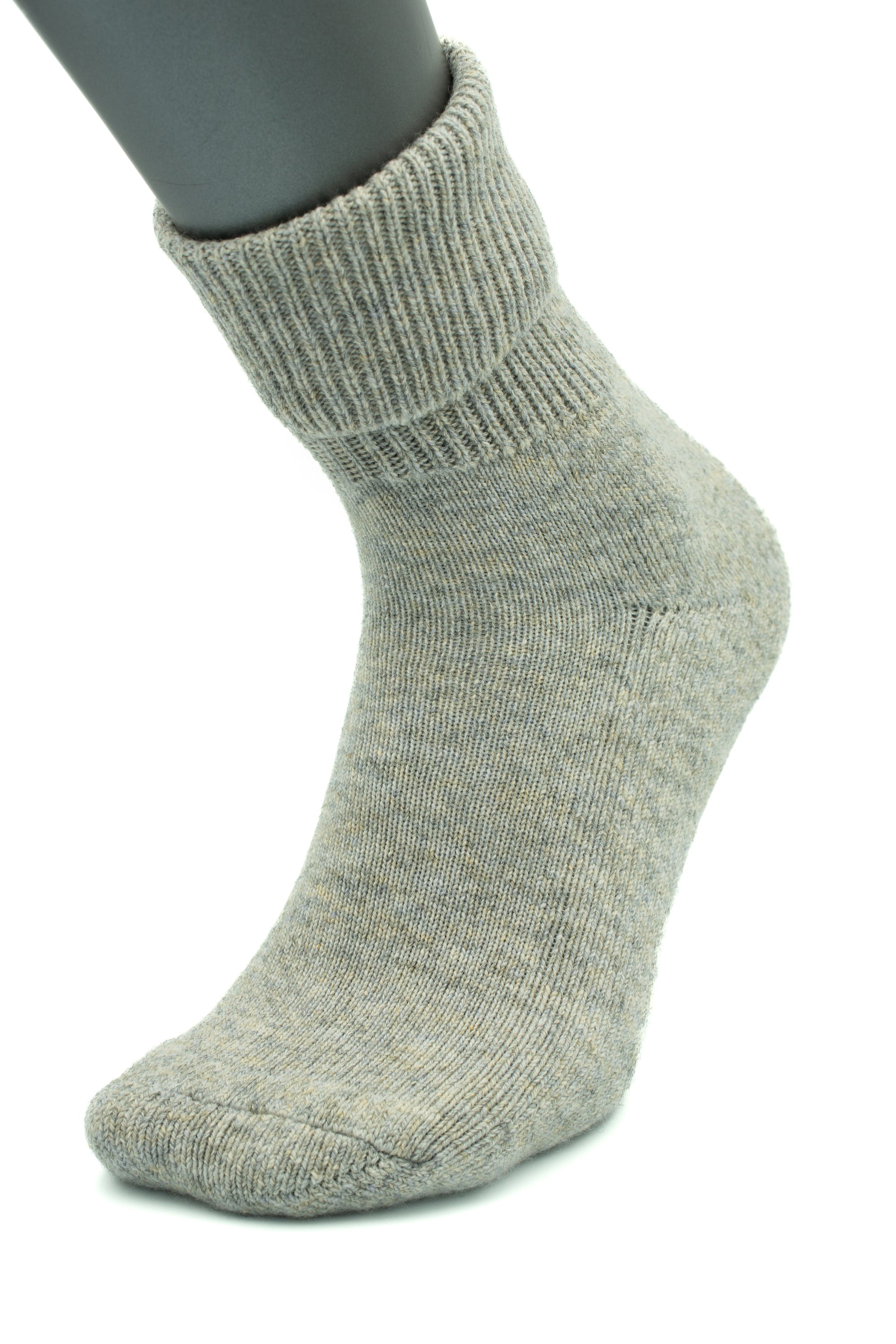 The Moggans NEW for 2025 Cashmere Luxury Bed Socks, made in Scotland, are shown in gray on a mannequin foot with a ribbed cuff and textured fabric, set against a white background.