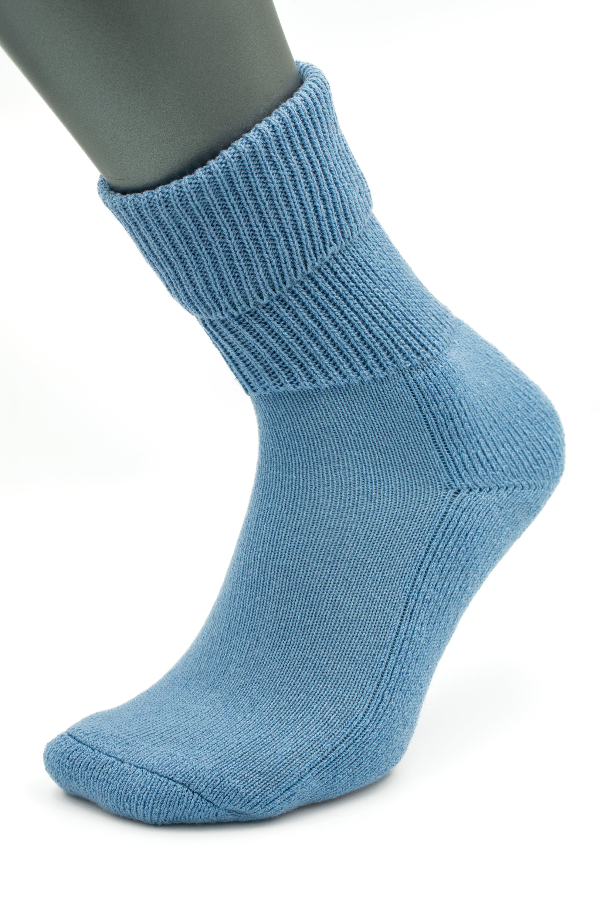 A mannequin foot wears a light blue, ribbed crew sock—Moggans Cashmere Luxury Bed Socks, made in Scotland—displayed on a plain white background.