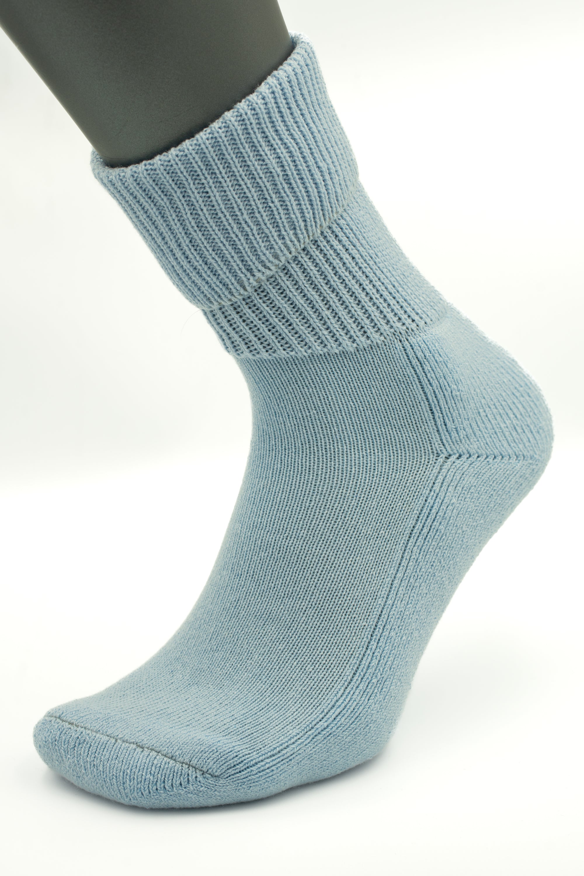 The Moggans Cashmere Luxury Bed Socks—Made in Scotland—are shown in light blue on a mannequin foot, side view, with a ribbed cuff and smooth finish, delivering ultimate comfort typical of premium cashmere bed socks.