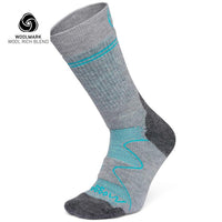 The Moggans Hiking Full Cushion Merino Crew Sock is gray with turquoise accents, a dark gray heel and toe, and features the Woolmark logo—ideal for cold weather thanks to its wool-rich Merino material.