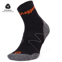 A black and grey Moggans Lightweight Merino Ankle Sock with orange accents stands upright to show the heel, toe, and side. The Woolmark logo and “WOOL RICH BLEND” text are displayed in the top left corner.
