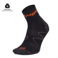 An ultralight Moggans Merino ankle sock with gray accents and orange branding stands upright, while the Woolmark logo and WOOL RICH BLEND text appear in the upper left corner on a white background.